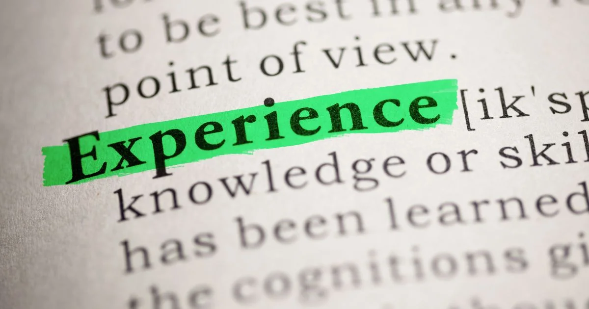 Dictionary page with the word Experience highlighted in green marker, surrounded by partial definitions referencing knowledge, skill, and what has been learned